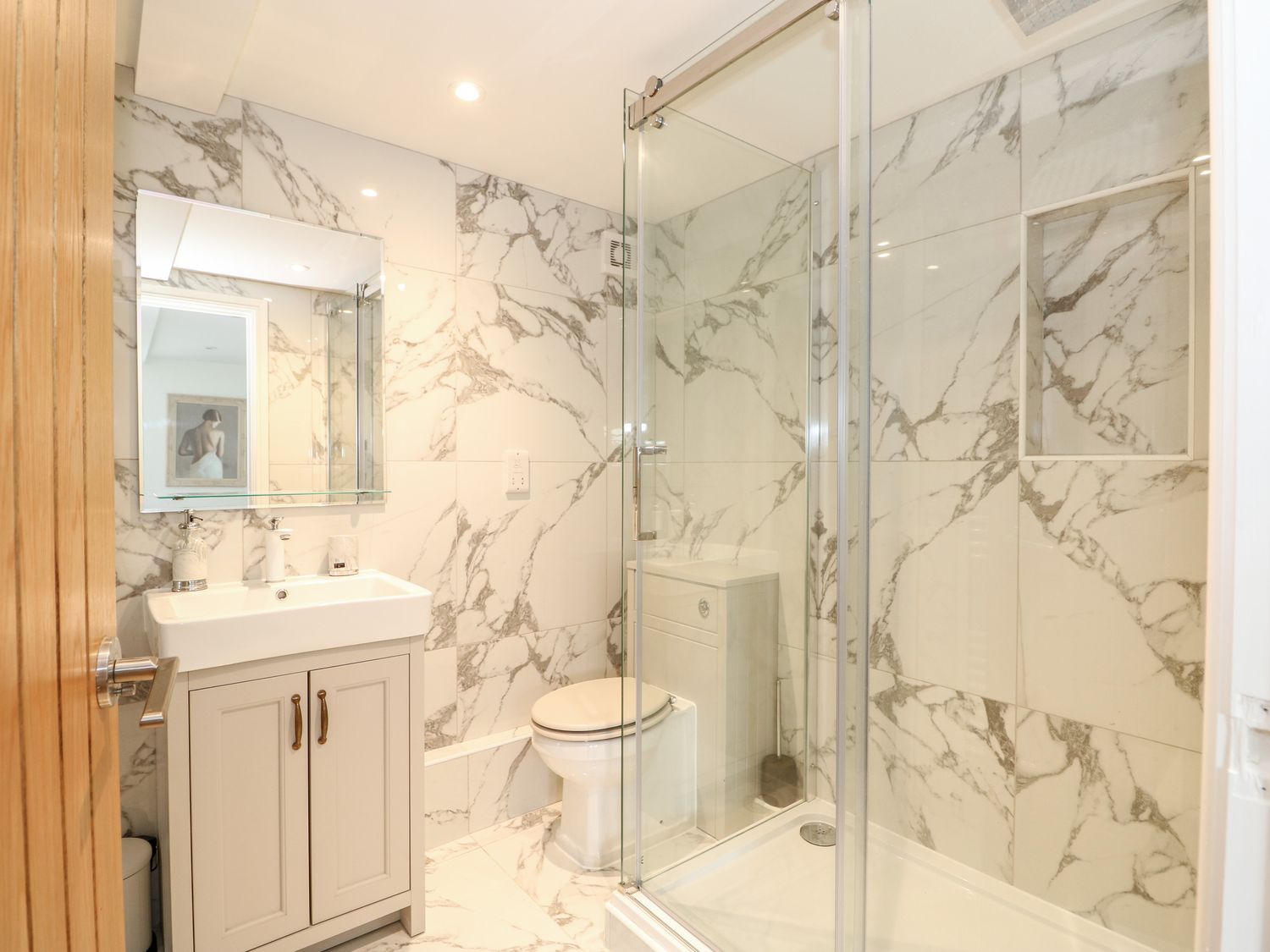 The Coach House en-suite shower room with marble-effect tiles, vanity and walk-in shower
